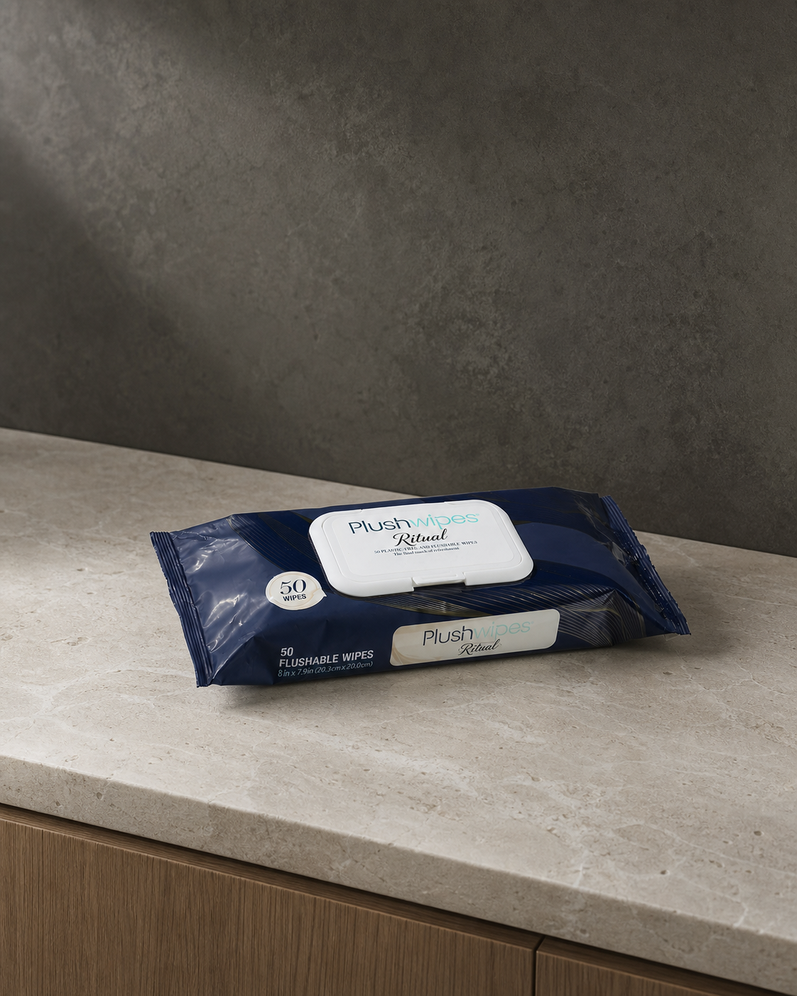 Plushwipes Ritual soft pack naturally photographed on a warm limestone ledge