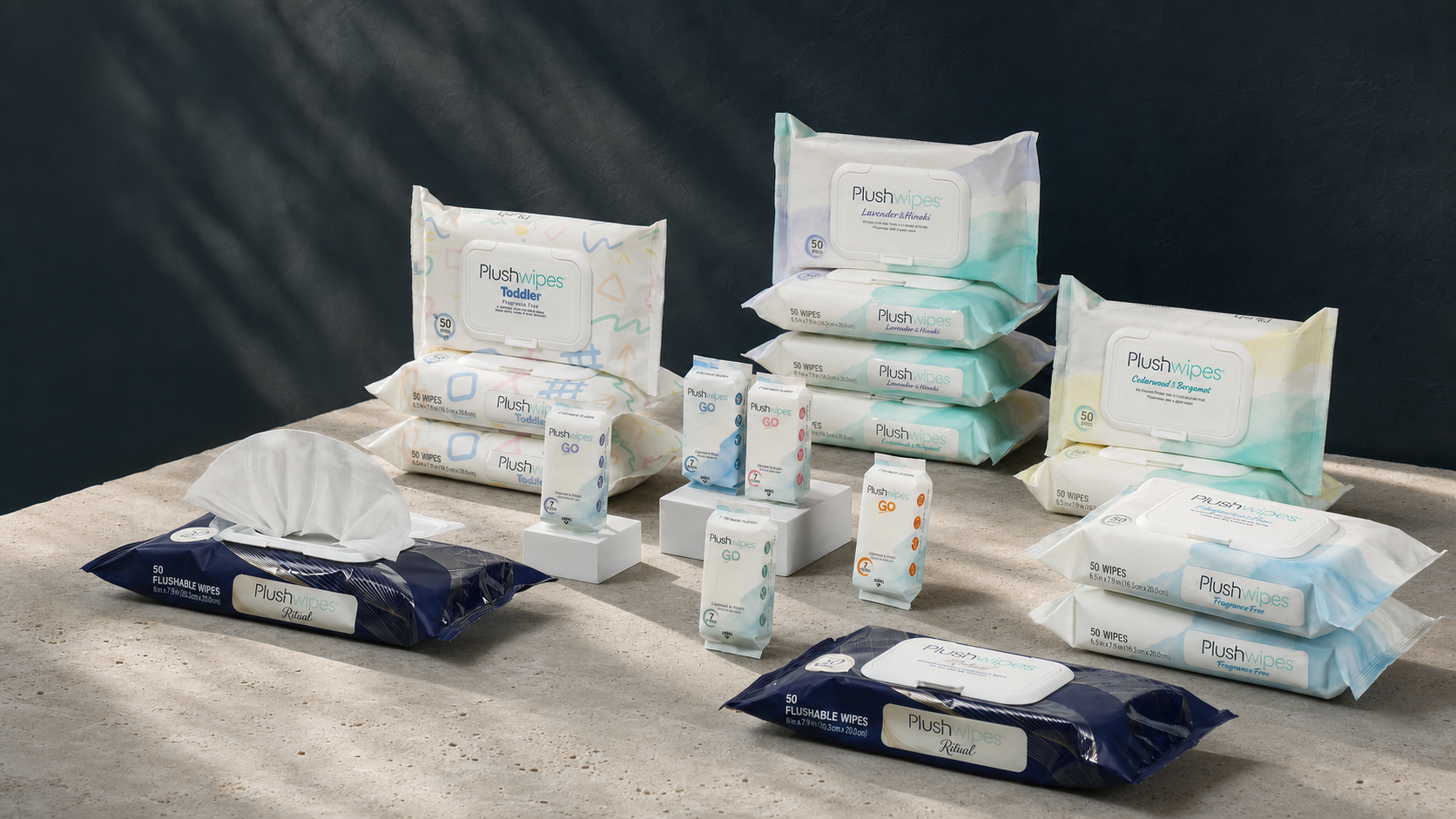 Plushwipes Ritual, Everyday, Go, and Toddler product family in a quiet ink-studio scene